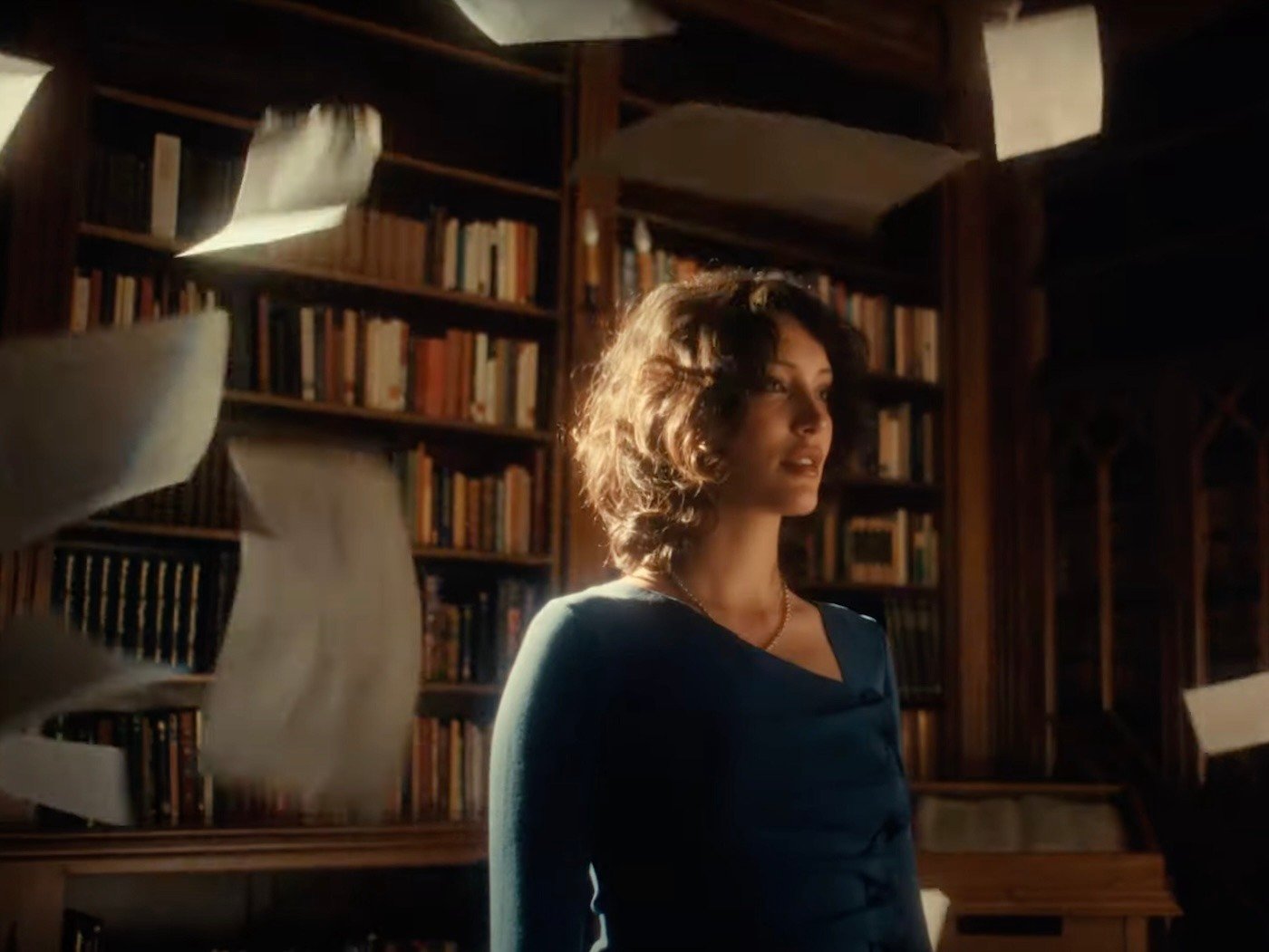 Woman in library, surrounded by papers tossed in the air 