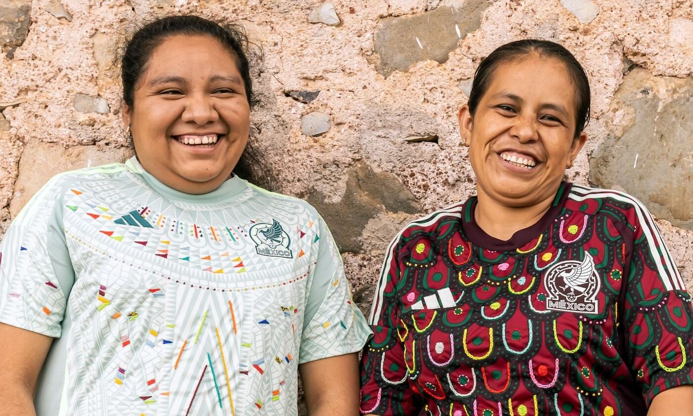 Two artisans wearing Mexico soccer jerseys they embroidered for Adidas 