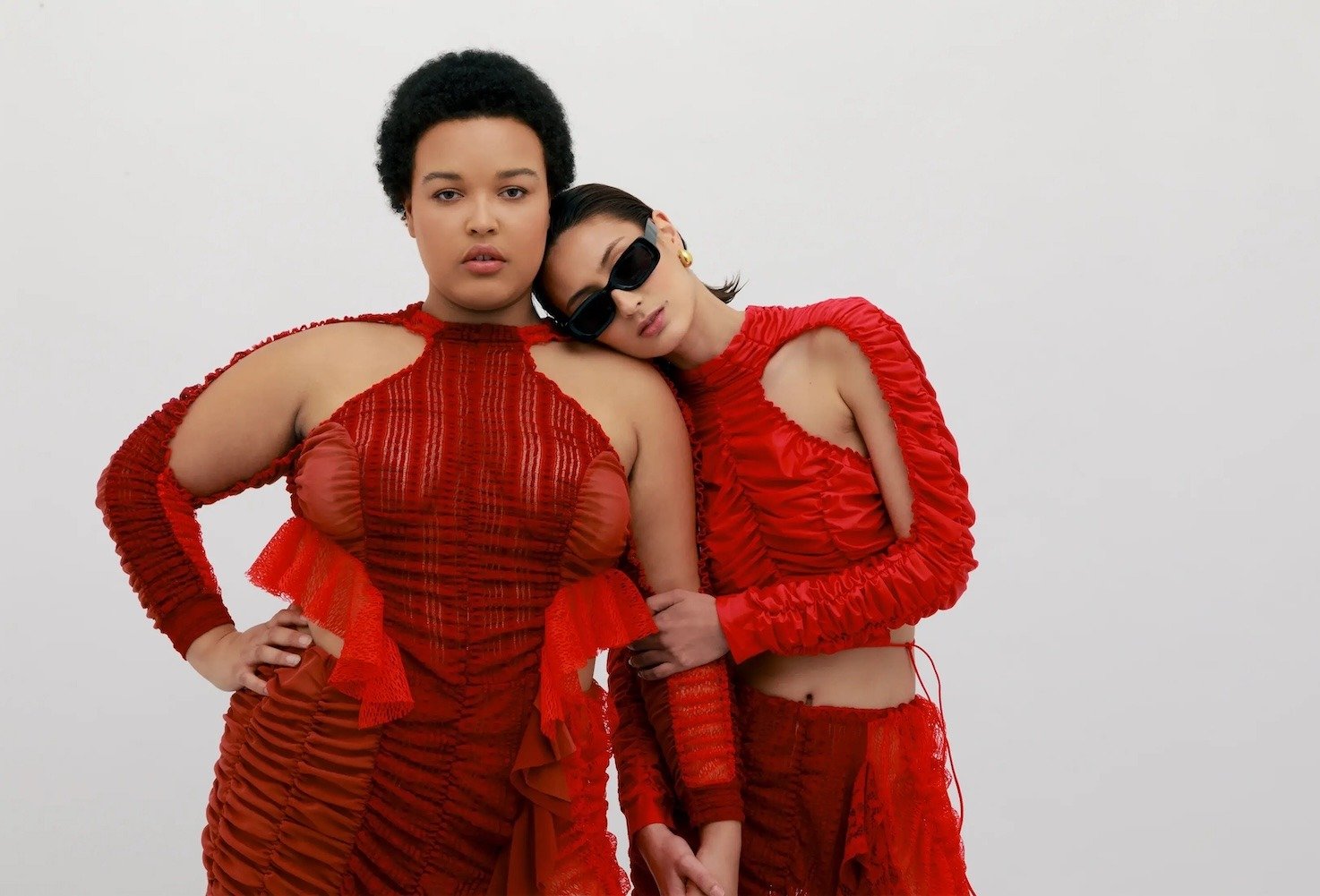 Two models with different body types in red garments by Ester Manas 