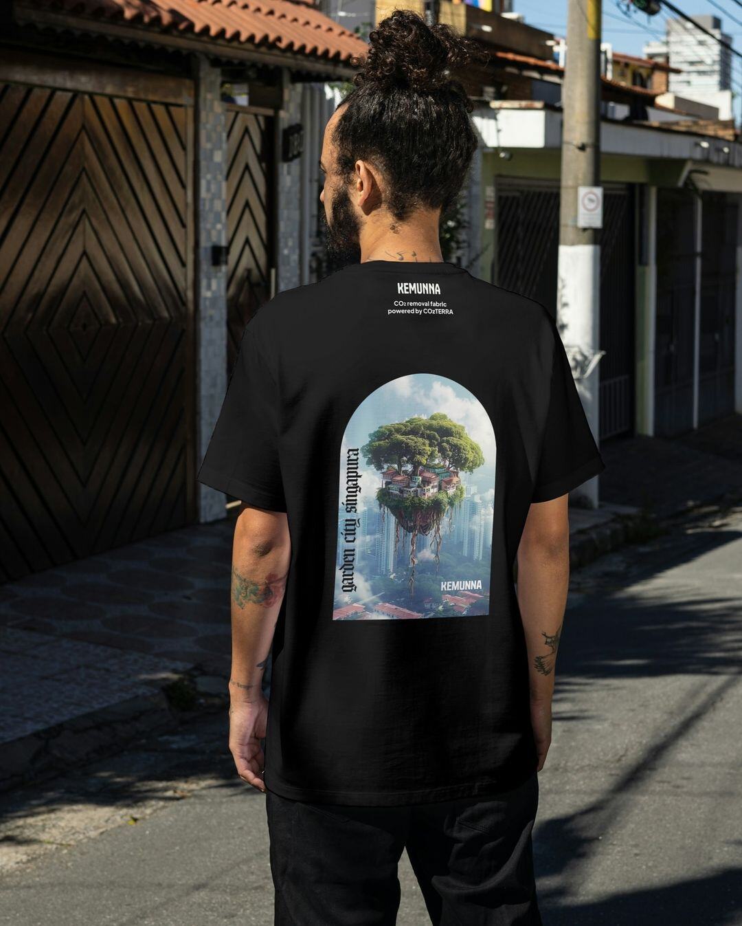 Viewed from behind, someone wearing a t-shirt with an illustration of 'Garden City Singapura' 