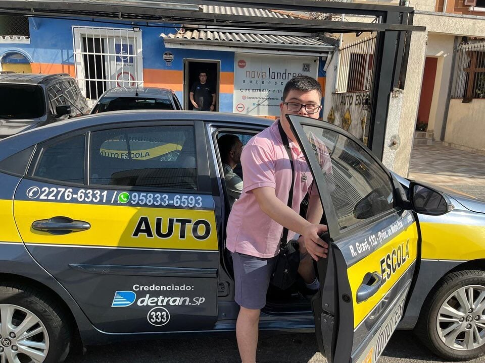 A person with Down syndrome getting into a car for a driving lesson 