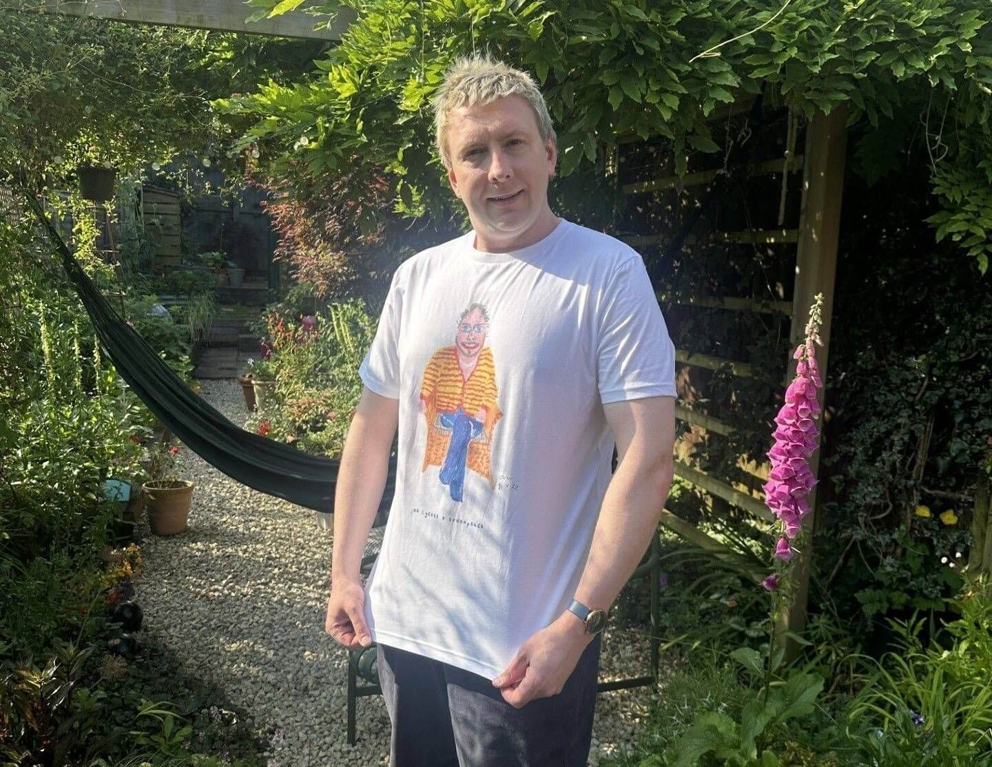 Joe Lycett wearing a t-shirt featuring his painting of Harry Styles 