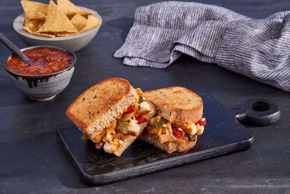 A sandwich melt on a wooden serving board 