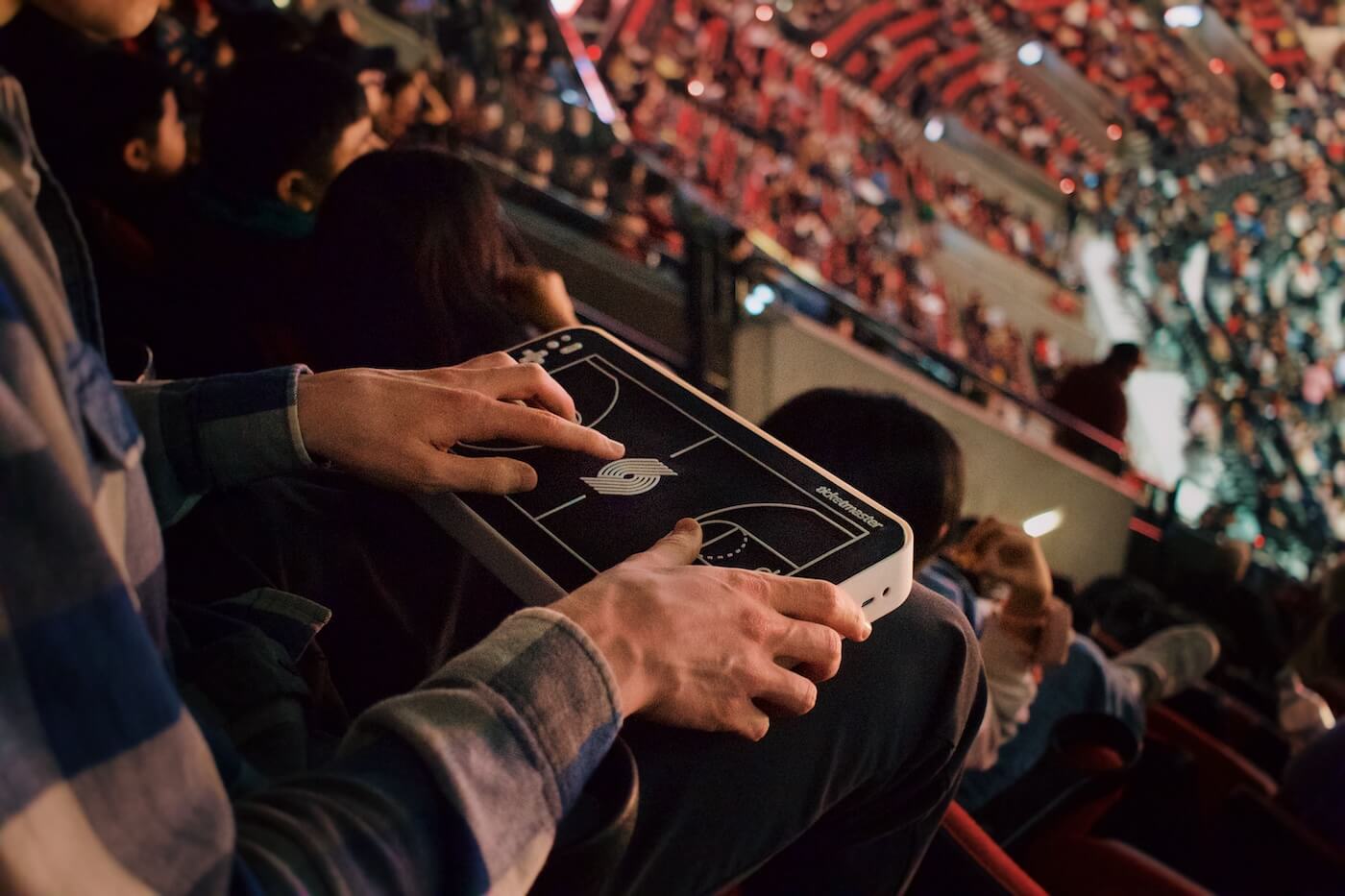 Basketball fan using a lap-based haptic device in a packed stadium 