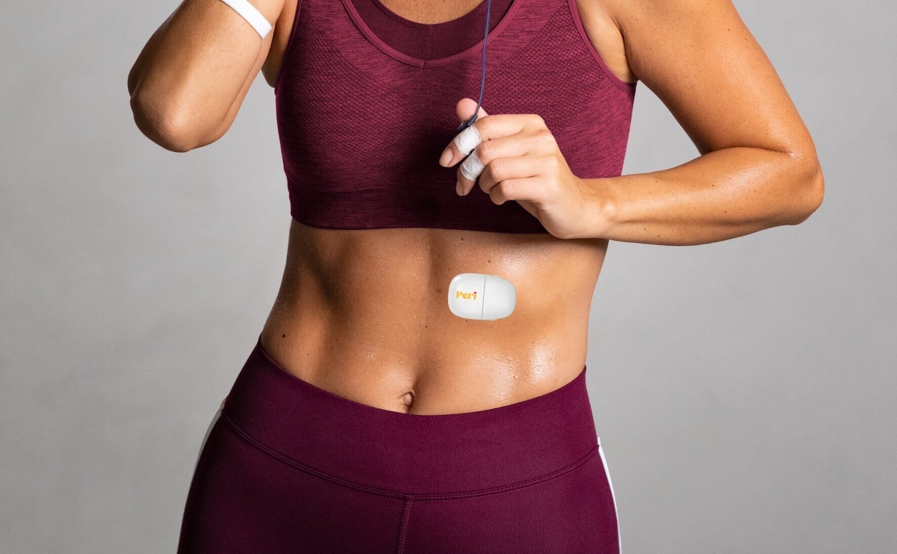 Female body in athletic gear, with a white sensor attached to the midriff 