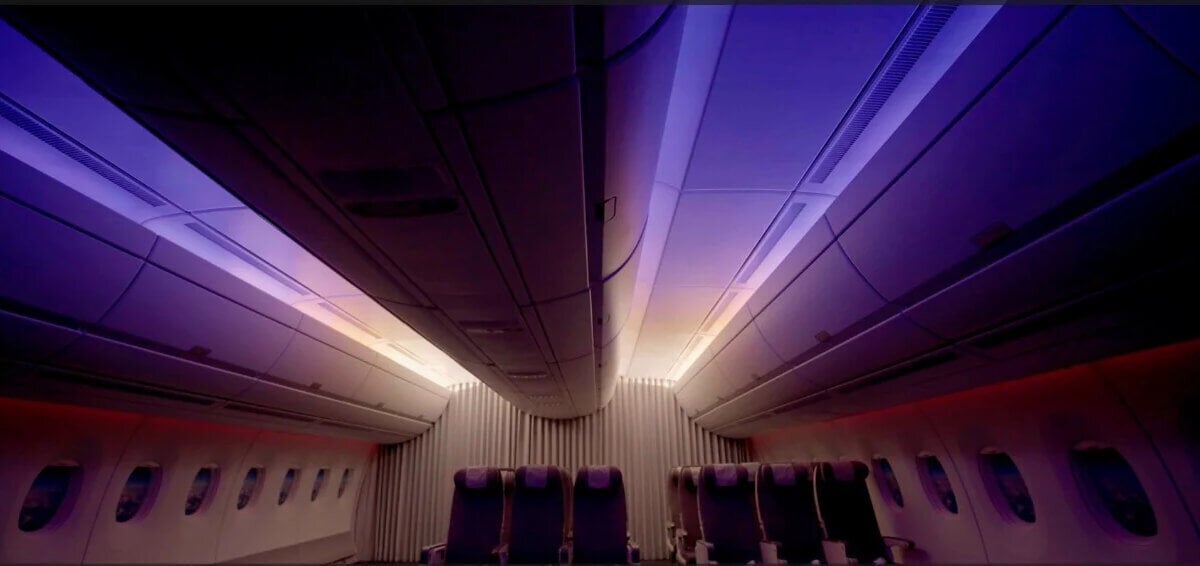 Dark purple lighting inside low-lit airline cabin 