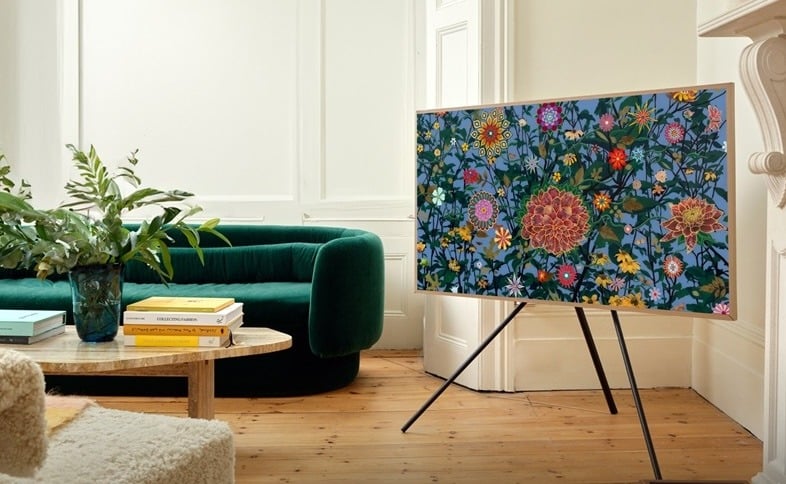 In a living room, Fred Tomaselli’s Irwin’s Garden is displayed on a Samsung television 