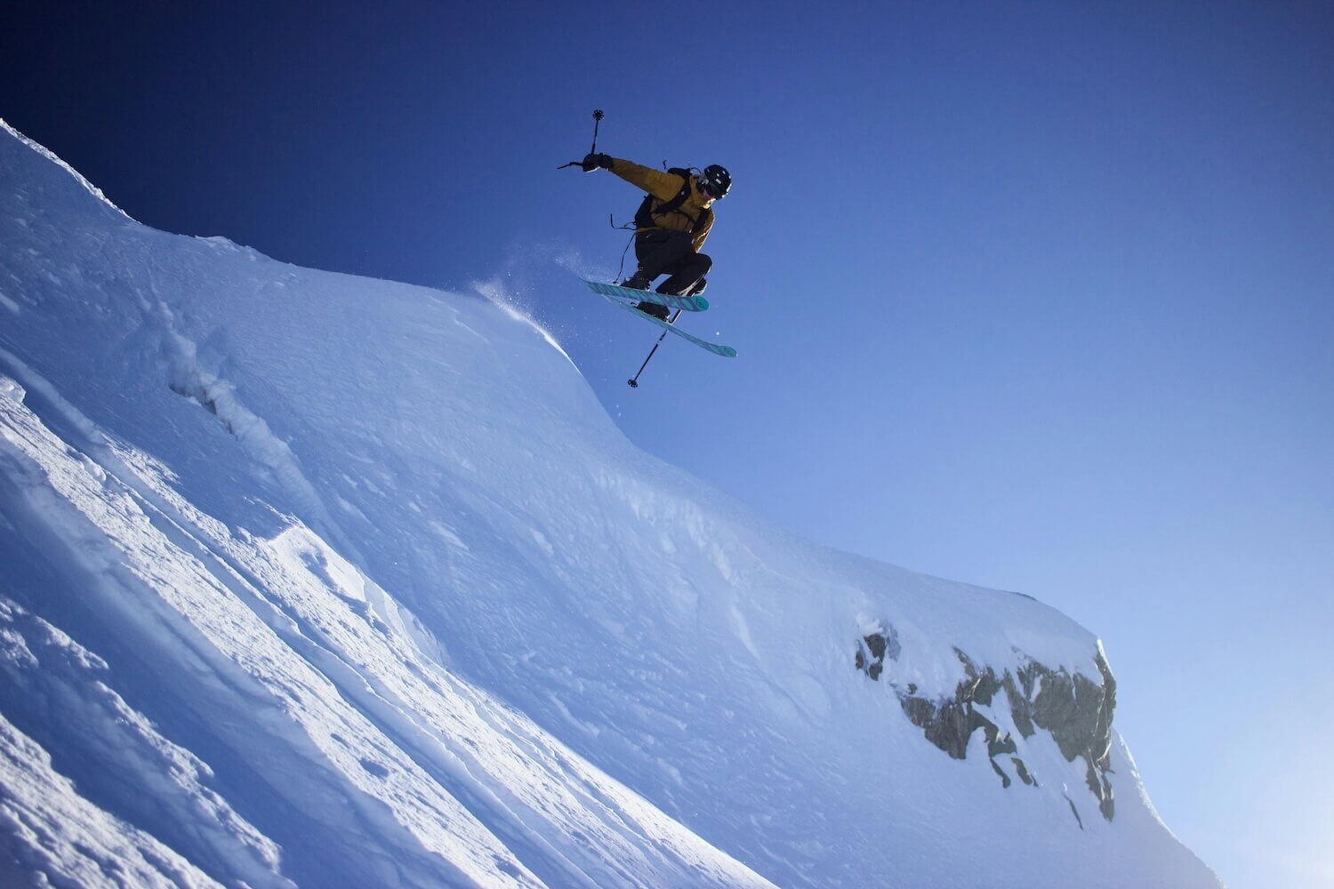 Person riding ski blades off a snow-covered mountain in Whistler, BC 