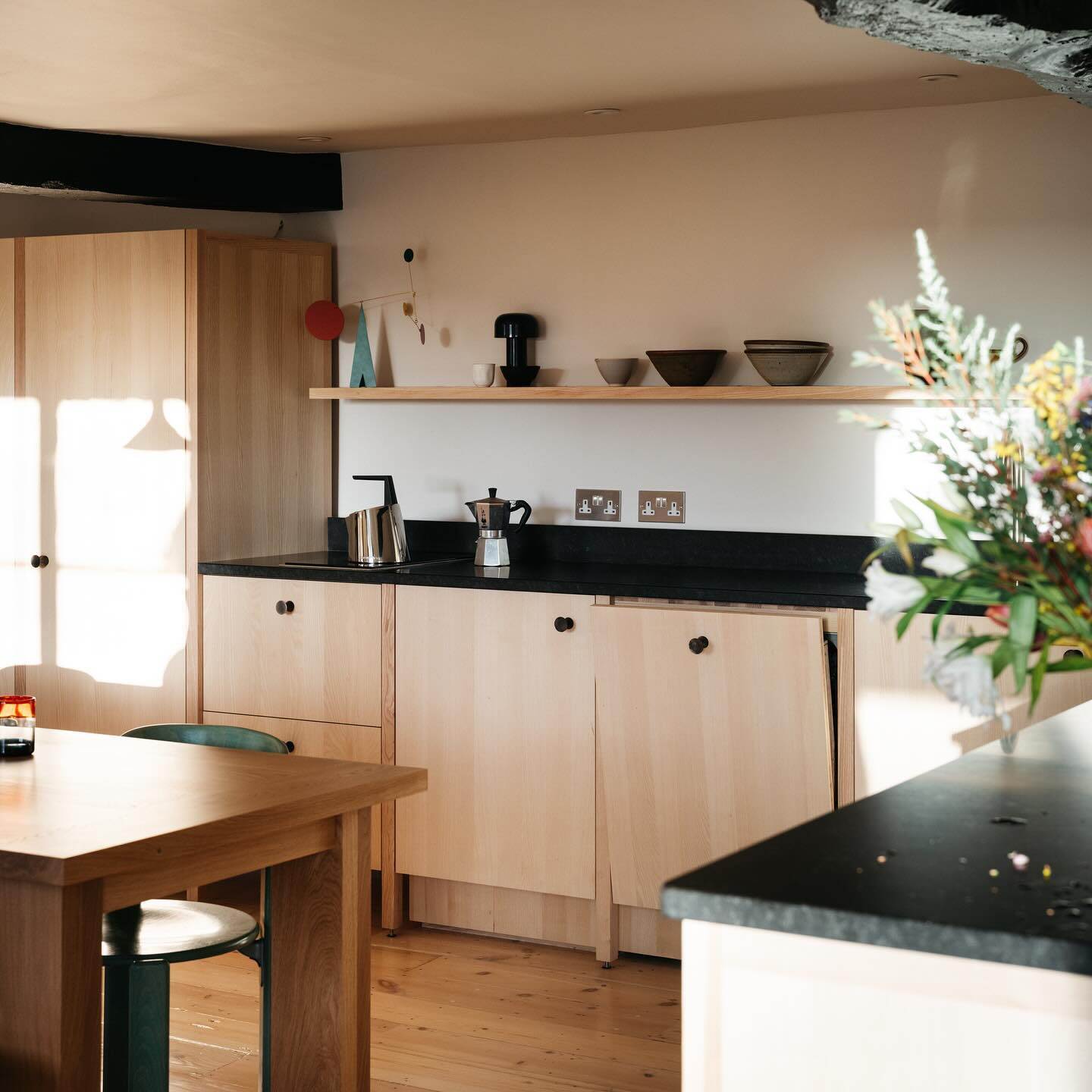 A kitchen featuring pale wood cabinets 