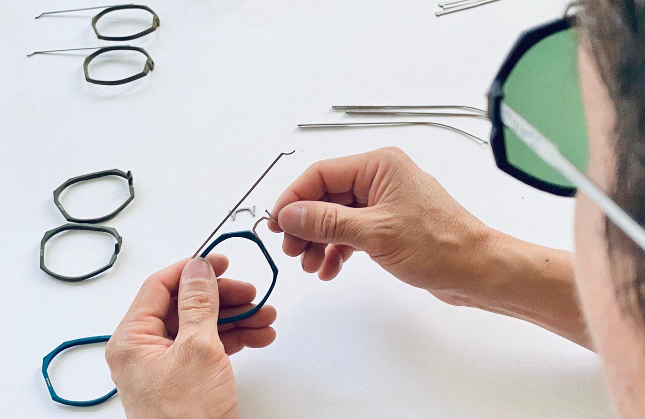 Hands assembling an eyewear frame 