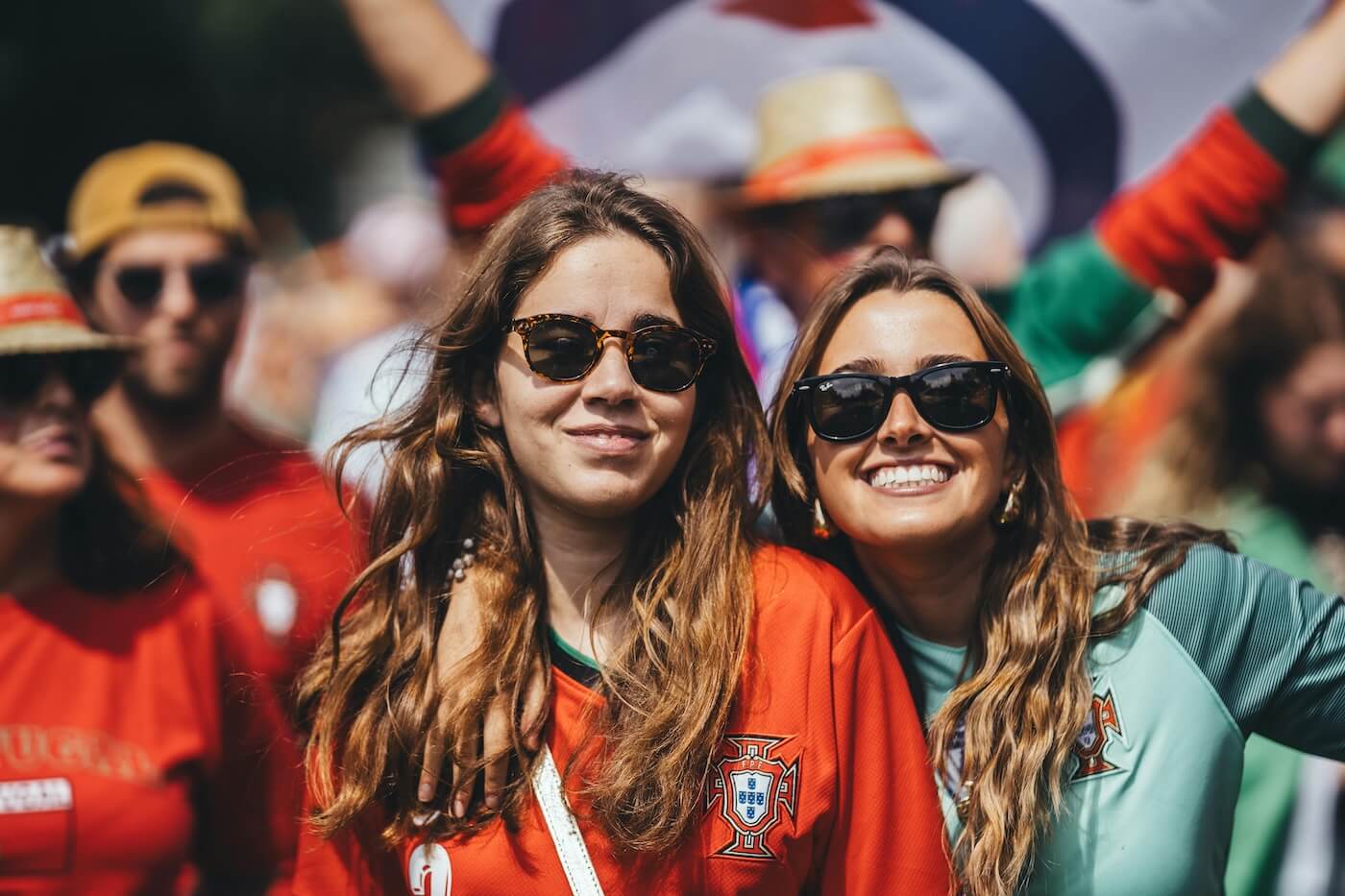 Two happy young sports fans wearing team shirts and sunglasses 